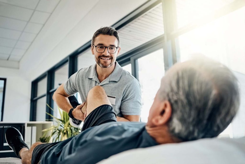 senior being stretched by a physical therapist